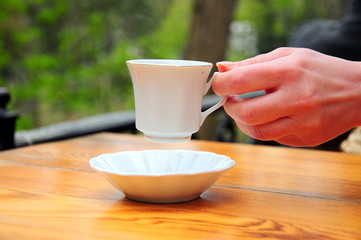 a hand holds a cup of tea (coffee)