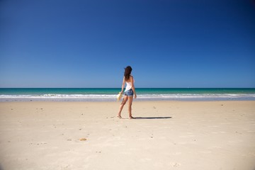 Fototapeta na wymiar side woman walking at Zahara beach