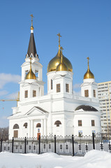 White church with golden domes and bell tower