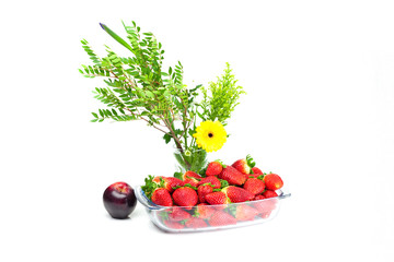 strawberries in a glass bowl, an apple and a flower isolated on