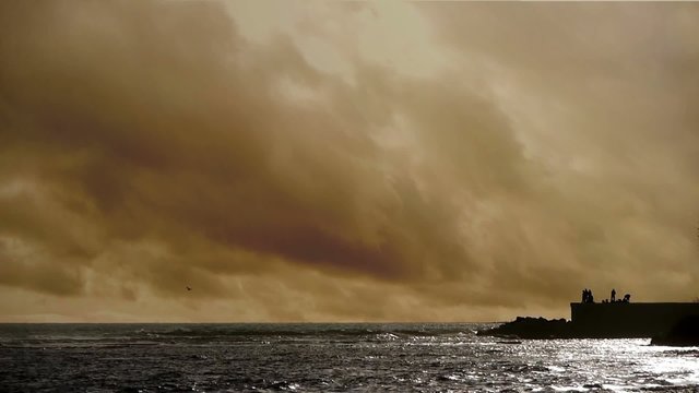 Sea with mole in sepia at sunset