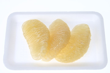 Three pomelo fruit on a white dish