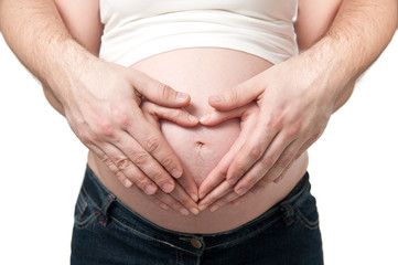 Heart shaped hands of pregnant woman and her husband