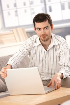 Young man working at home using laptop