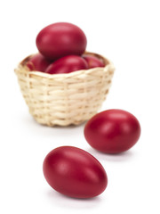 a wicked basket and two red eggs on white