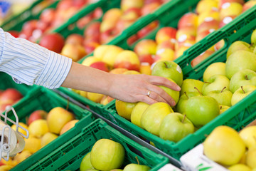 frau kauft äpfel im supermarkt