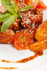 portion of sesame chicken served on a white plate