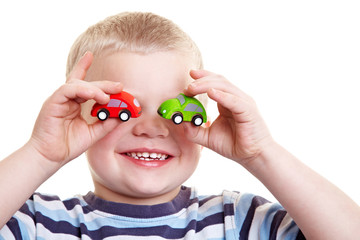 Kind hält Autos vor die Augen