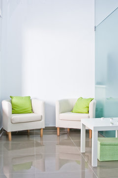 Brandable waiting room with two armchairs and white wall.