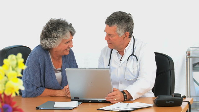Woman looking at the laptop of her doctor