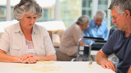 Elderly couple playing dominos - Powered by Adobe
