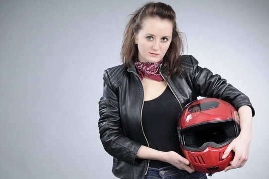young motorcyclist posing with red helmet