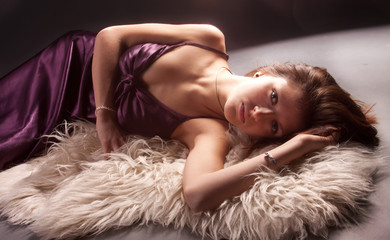 sexy caucasian girl in elegant dress lying on the carpet