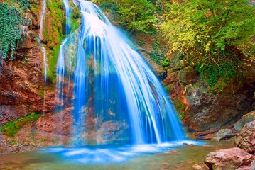 beautiful spring waterfall on a mountain river