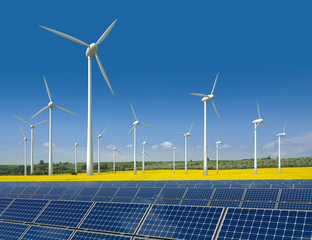 Windkrafträder und Solarmodule in einem Rapsfeld