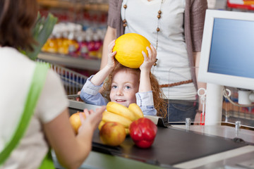 kind an der kasse im supermarkt