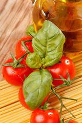 pasta, olive oil and tomatoes on the wood background