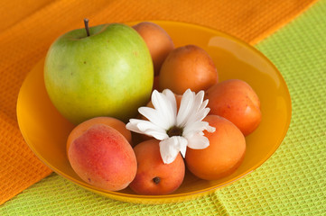 The ripe apricot and green apple lays on towels