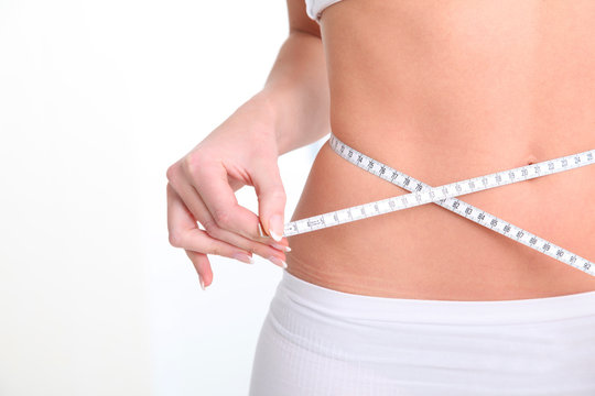 Slim woman's waist and measure tape