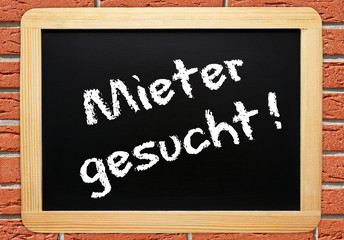 Fototapeta premium Mieter gesucht ! - Konzept Tafel mit Hauswand