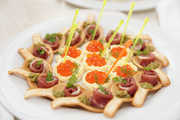 Canapes with ham and salmon caviar tartlets