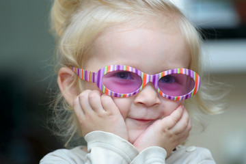 smiling child girl at sunglasses