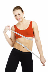 Sport woman with measuring tape posing against white background