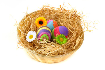Colorful Easter eggs on hay in the basket