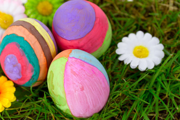 Fototapeta na wymiar Colorful Easter eggs on the grass with flowers