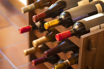 Red and white wine bottles stacked on wooden racks
