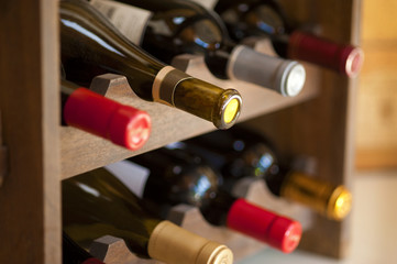 Red and white wine bottles stacked on wooden racks