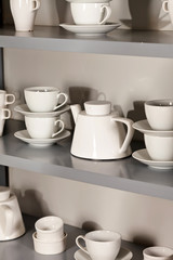 Obraz na płótnie Canvas white cups on the shelf