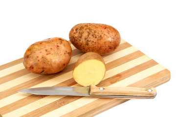 Raw potato tubers lying on a cutting board