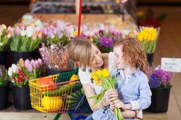 Fotobehang Bloemenwinkel moeder en dochter kopen tulpen