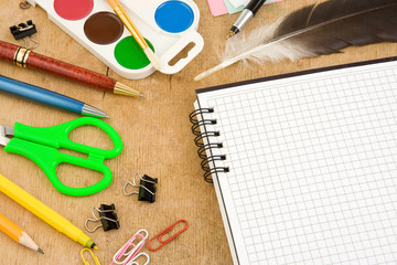 school accessories and checked notebook on wood