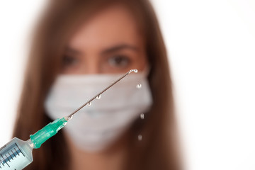 Portait of a nurse showing a syringe isolated