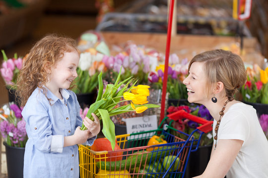 mutter und tochter mit tulpen im supermarkt
