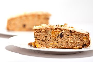 Carrot cake with almonds on a white plate