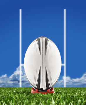 Rugby ball on field with goal posts