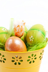 Yellow metallic bucket with colorful Easter eggs