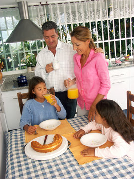 Familia desayunando en la cocina.