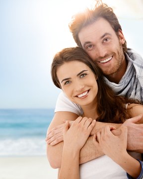Happy young couple embracing on summer beach