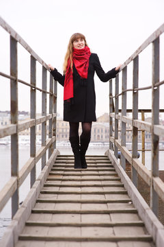 Young girl in the red scarf standing on stairs