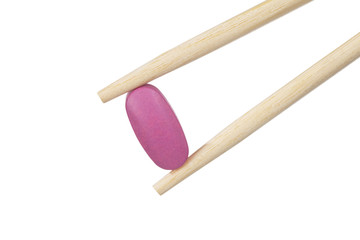 chopsticks with pill. Isolated on white background.