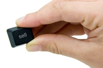 hand holding button says sell
