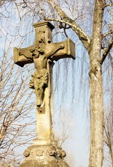 sandstone tomb cross with Christ on cemetery in Jaslo