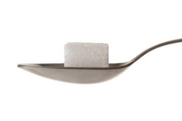 Lump sugar (sugar cube) on a spoon
