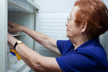 Older woman looking for food in the fridge