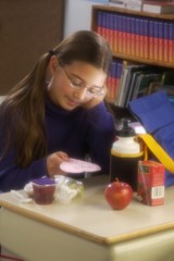 Obraz na płótnie Canvas Girl Eating Lunch At Desk