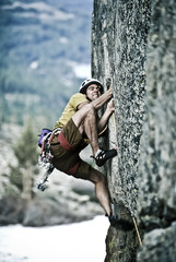 Rock climber clinging to a cliff.